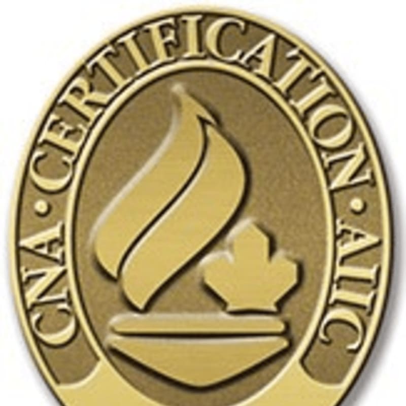 A gold medal with the words "CNA CERTIFICATION" encircling a flame and a maple leaf is presented against a blurred background.