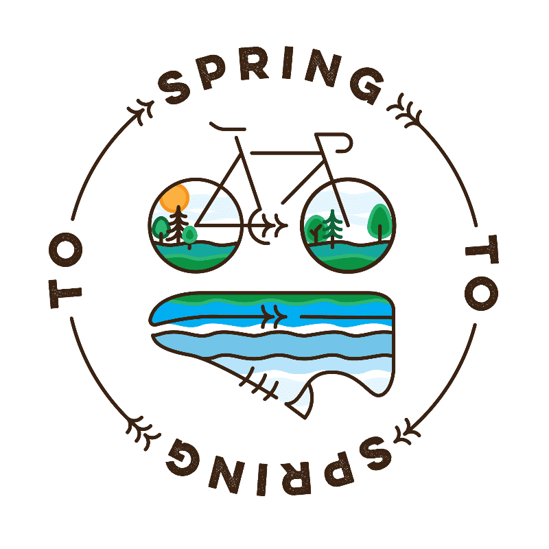 A bicycle with wheels depicting spring landscapes is positioned above a stylized shoe with a river flowing through it, all enclosed within a circular frame with the words "TO SPRING TO SPRING" written around it.