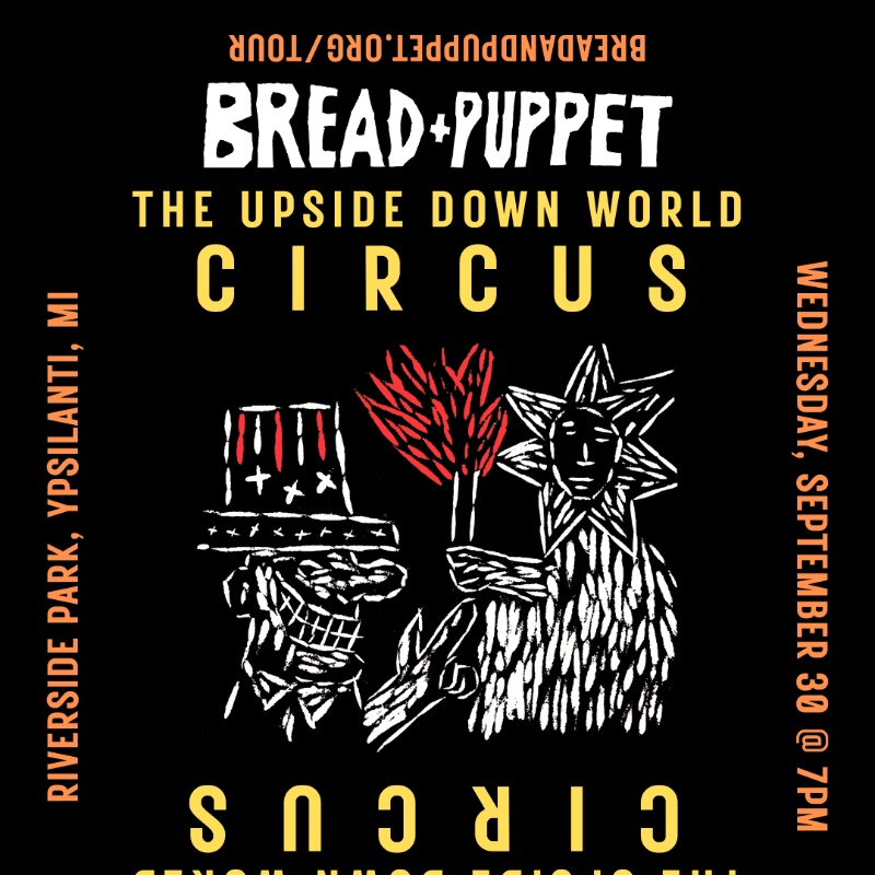 A black poster advertises "Bread + Puppet: The Upside Down World Circus" with a white illustration of two figures in the foreground and event details in the background.