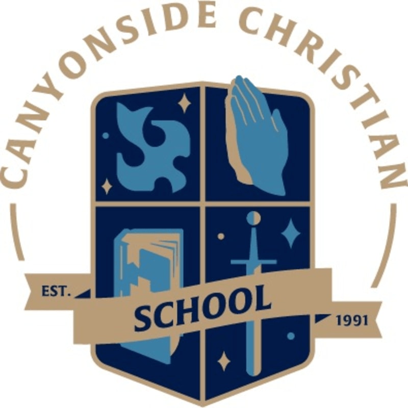 A blue and tan crest with four quadrants depicting a dove, praying hands, an open book, and a sword, is centered on a tan banner that reads "SCHOOL" and is framed by a circular inscription "CANYONSIDE CHRISTIAN" with "EST. 1991" on either side.