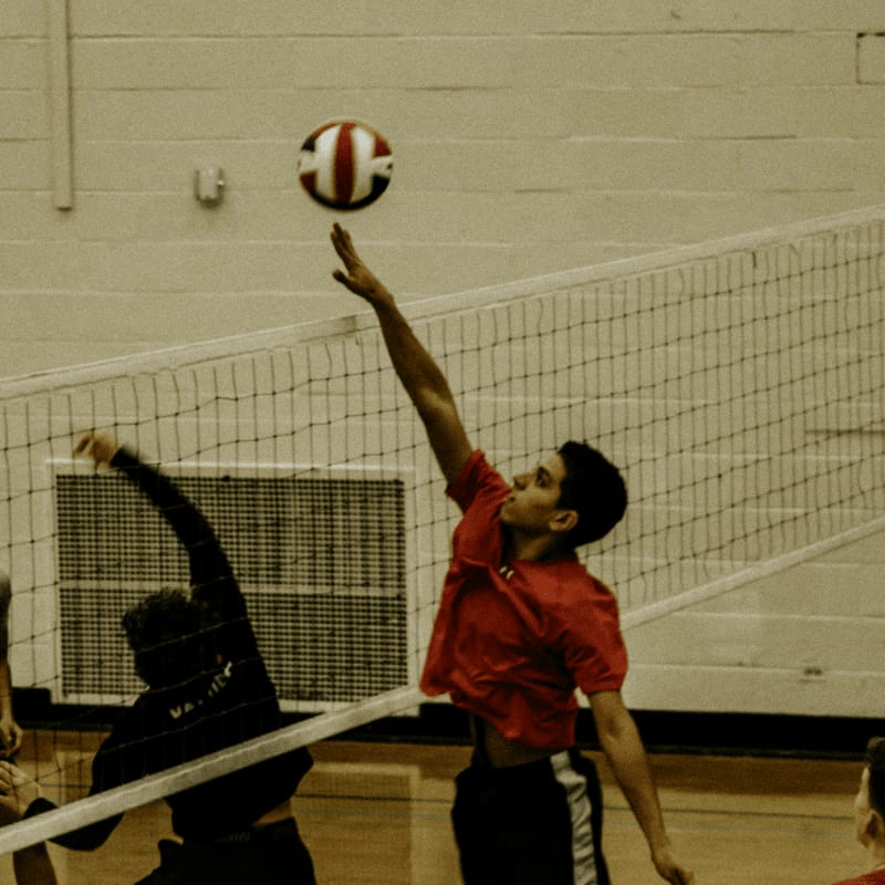 2 boys playing volleyball on court