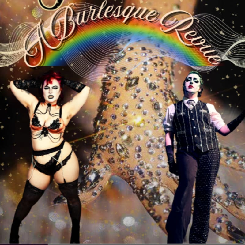 Two performers, one in a burlesque outfit and the other in a suit with dramatic makeup, stand before a glittering, sequined backdrop with a rainbow arching overhead.