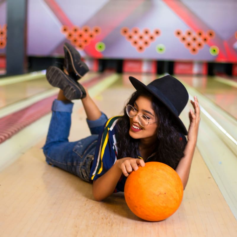 girl in blue and white school uniform holding orange pumpkin