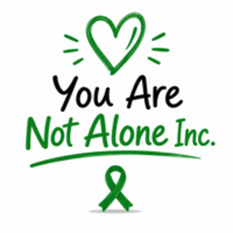 A green heart and a green awareness ribbon are above and below the text "You Are Not Alone Inc." on a white background.
