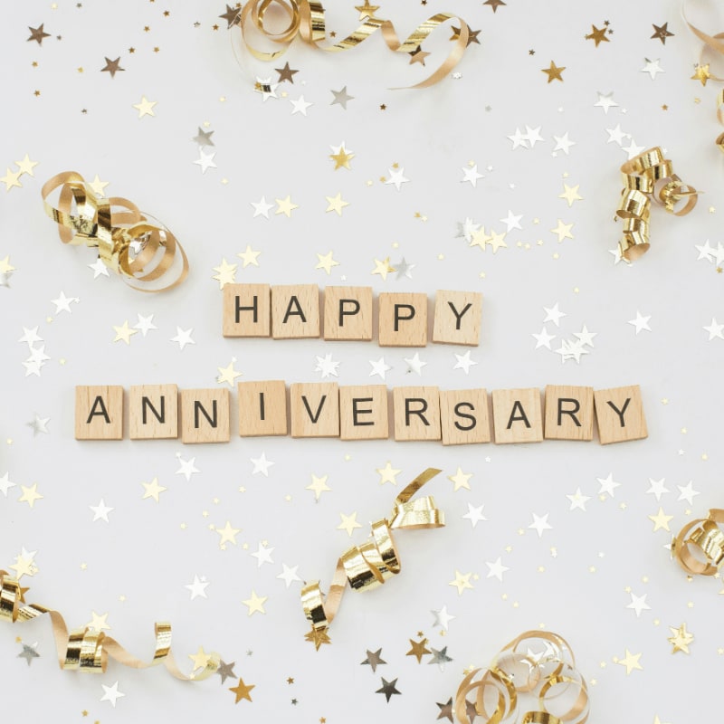 a happy anniversary spelled with scrabbles on a white background