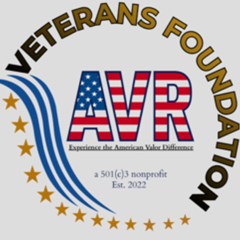 A circular logo with "VETERANS FOUNDATION" curved around the top, featuring the letters "AVR" in an American flag design in the center, with blue waves and gold stars on the left, all against a light gray background.