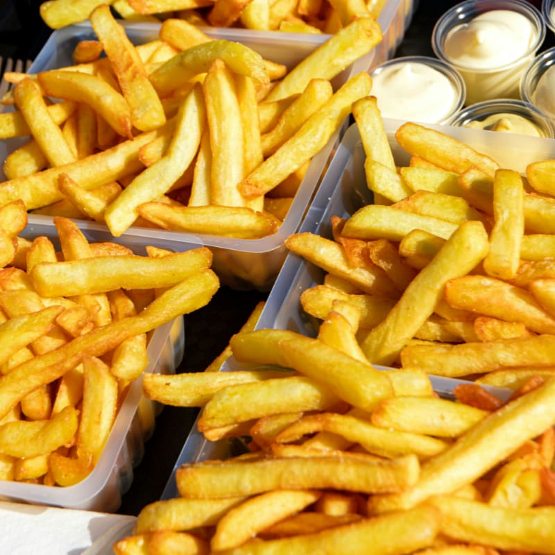several trays of french fries sitting on a table