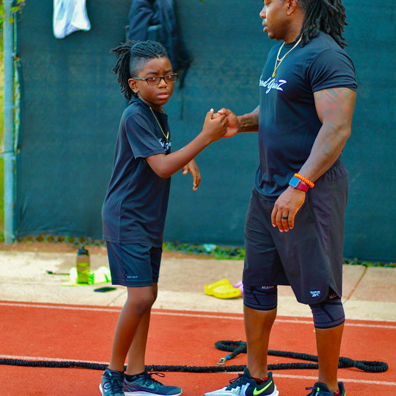 a man and a little girl shaking hands on a tennis court