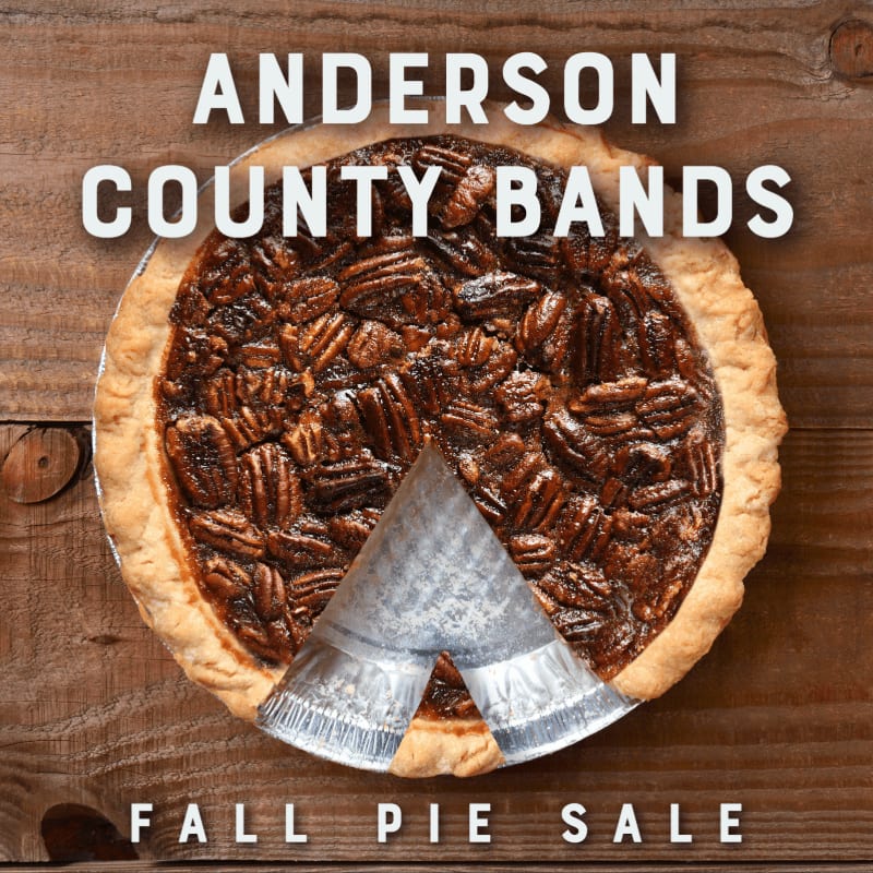 A pecan pie with a slice removed sits on a wooden surface, with "ANDERSON COUNTY BANDS FALL PIE SALE" text above and below.