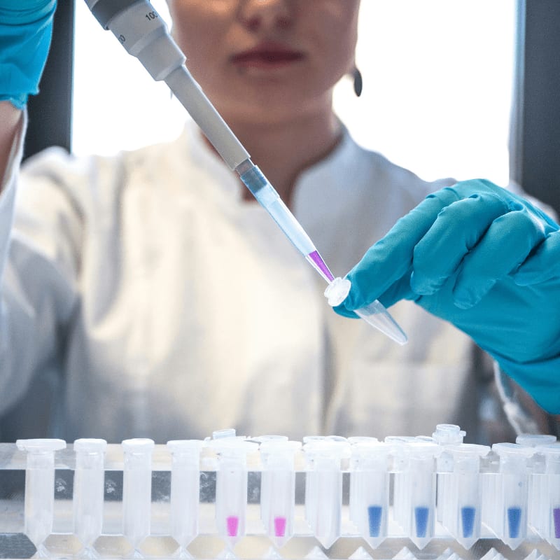 scientist using pipette with test tubes in lab