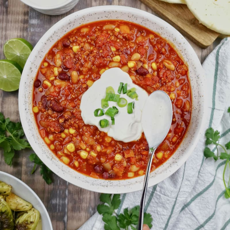 a bowl of chili with sour cream on top