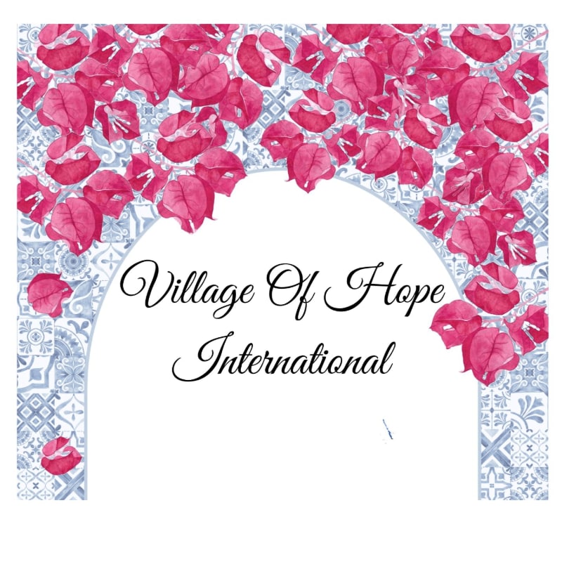 Pink bougainvillea flowers arch over a white space with the words "Village Of Hope International" written in elegant script, set against a background of blue and white patterned tiles.