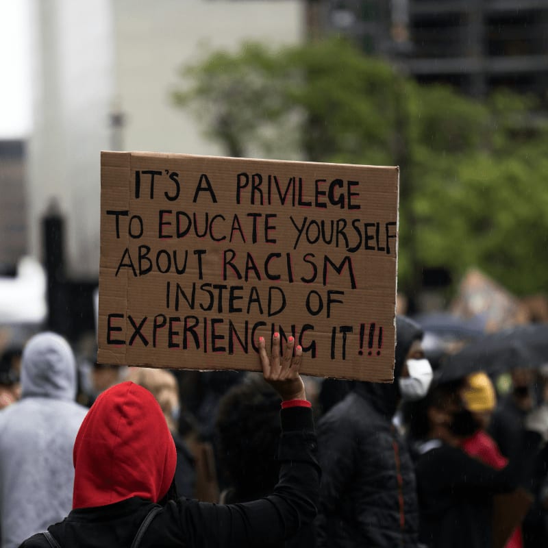 people holding brown wooden signage during daytime