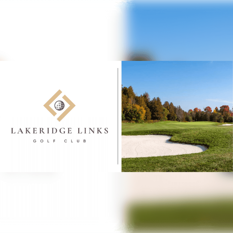 A sandy golf course bunker in the foreground is bordered by lush green grass, with a backdrop of autumn trees under a clear blue sky.