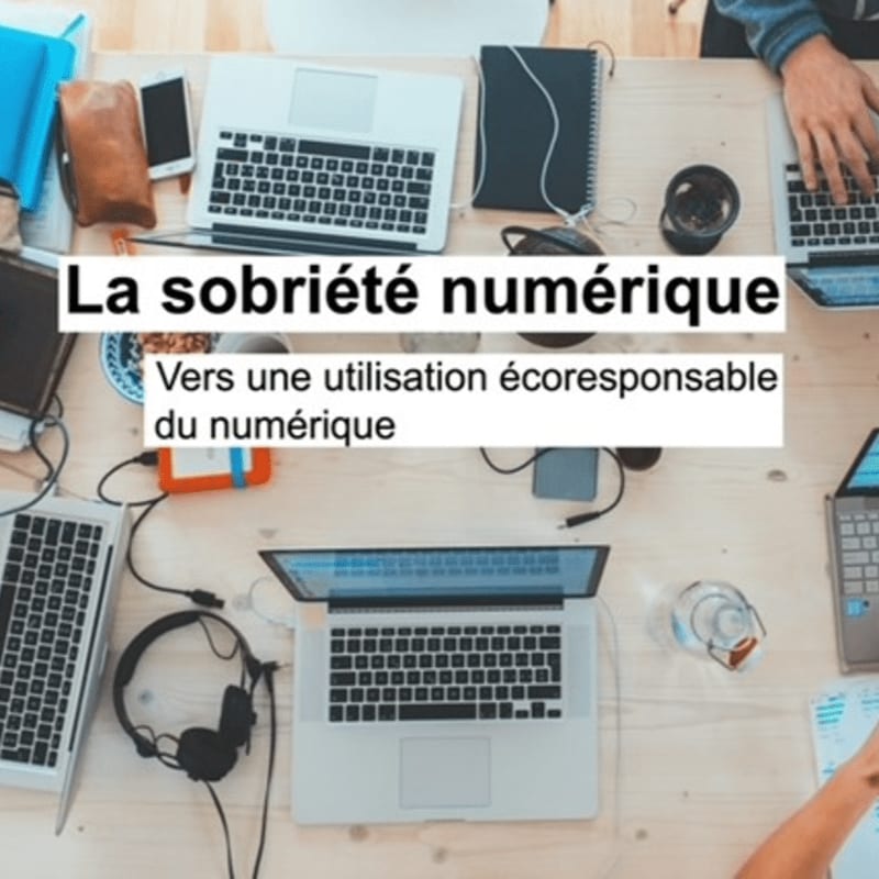 Laptops, headphones, and a phone are spread across a wooden table in the foreground, with a text overlay in French about digital sobriety in the background.