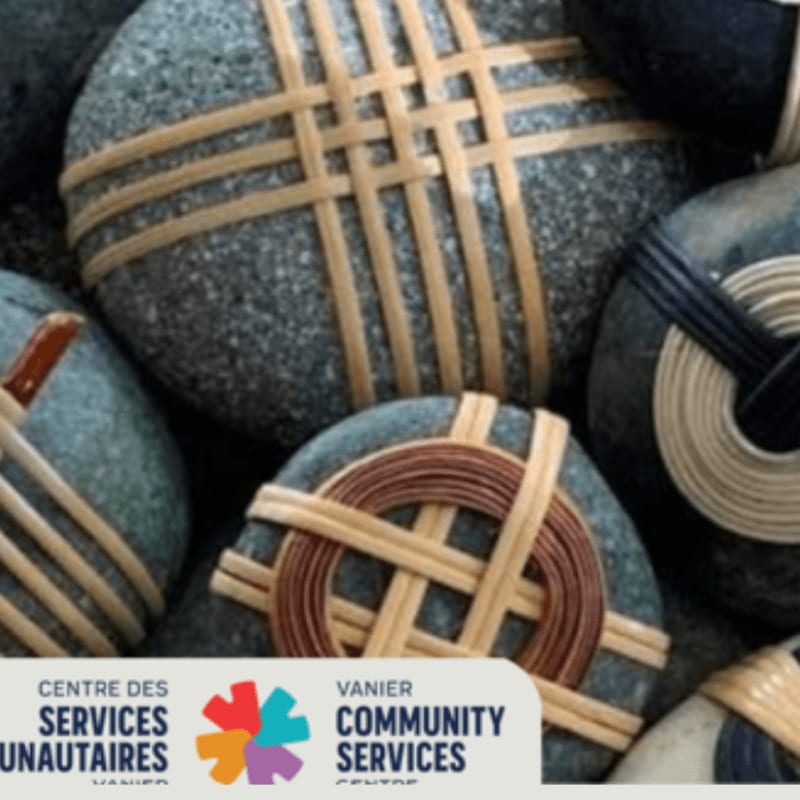 Smooth, grey stones wrapped with natural fibers are artfully arranged in the foreground, with a logo for Vanier Community Services visible at the bottom.