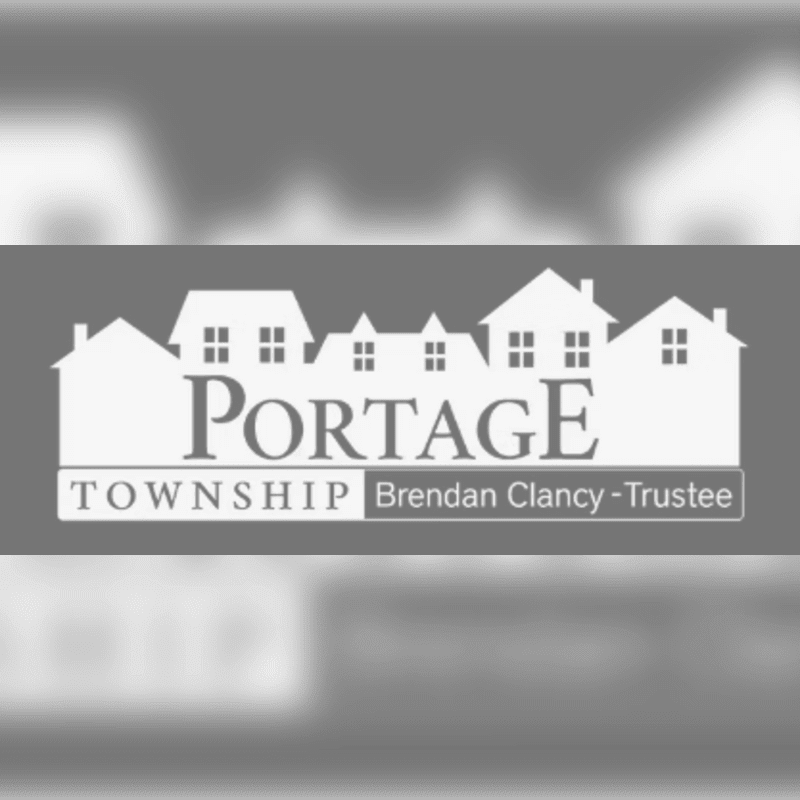 A white silhouette of houses with the text "PORTAGE TOWNSHIP Brendan Clancy-Trustee" in the foreground is set against a blurred, gray background of more houses.