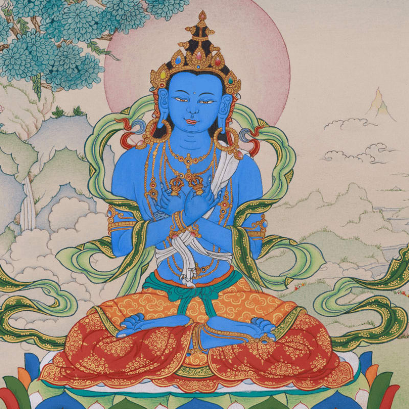 A serene blue deity with a crown and ornate jewelry sits cross-legged on a lotus throne, with a soft pink halo behind its head, against a backdrop of misty mountains and flowering branches.