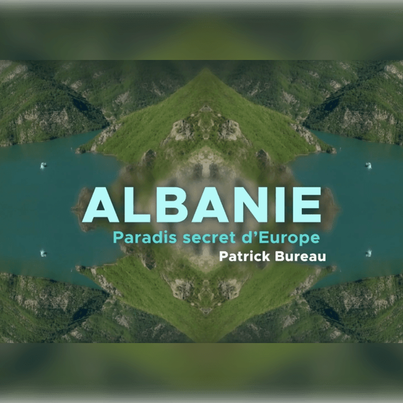 A symmetrical landscape of a serene lake surrounded by lush green mountains frames the text "ALBANIE Paradis secret d'Europe" in the foreground.