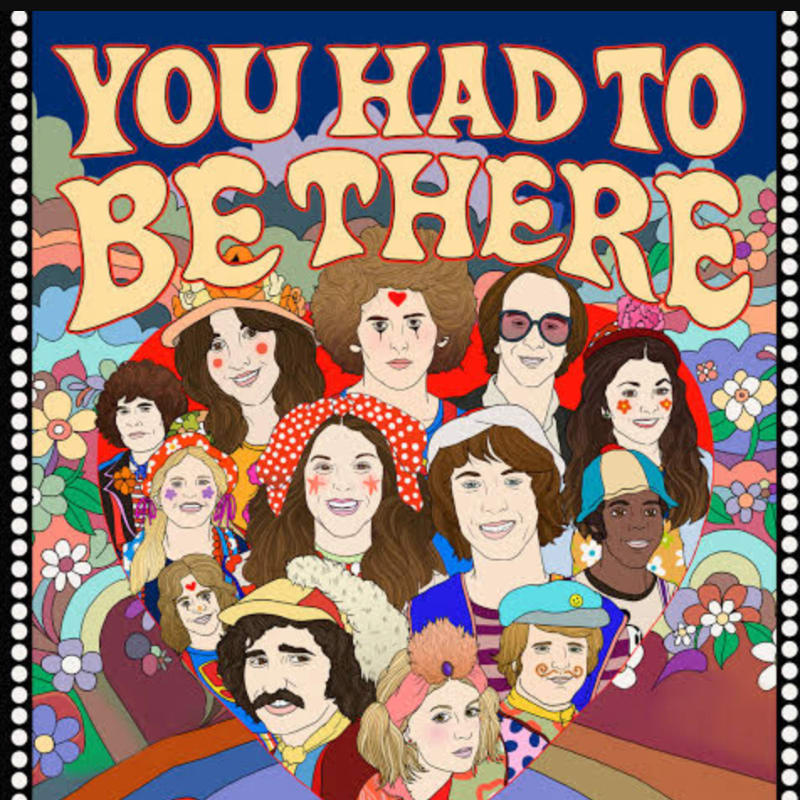 A group of people with colorful, retro hairstyles and clothing are smiling in the foreground, set against a psychedelic background of flowers and rainbows with the words "YOU HAD TO BE THERE" in large, bubbly letters.