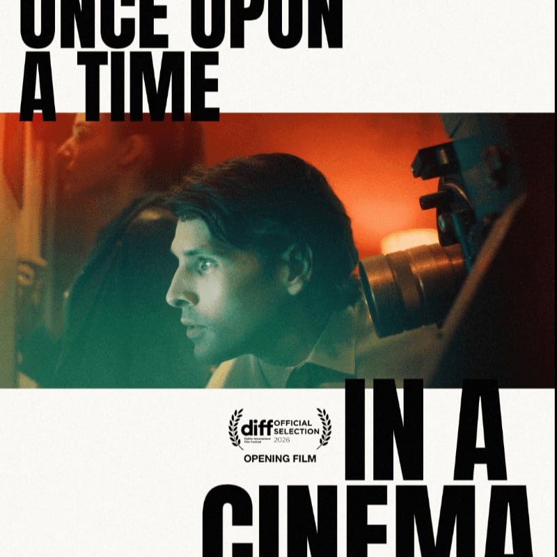 A man looks intently towards a camera in the foreground, with the words "ONCE UPON A TIME IN A CINEMA" framing the scene in bold black text.