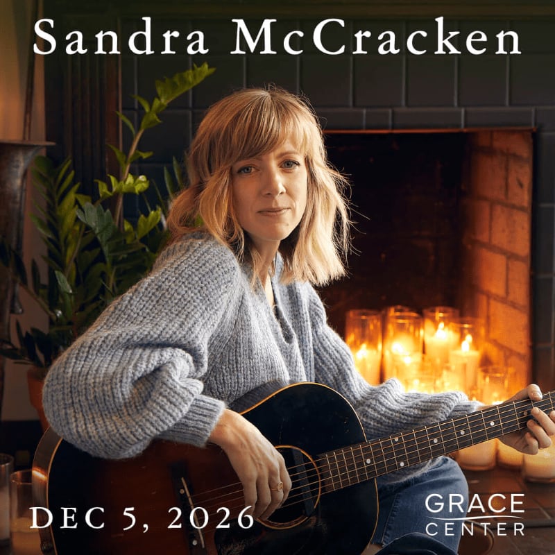 A woman with blonde hair and a gray sweater plays an acoustic guitar in front of a fireplace filled with candles, with the text "Sandra McCracken" and "DEC 5, 2026" visible.