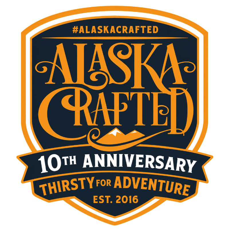 A dark blue and orange shield-shaped logo with ornate lettering reading "ALASKA CRAFTED" and "#ALASKACRAFTED" at the top, a mountain graphic below, and "10TH ANNIVERSARY THIRSTY FOR ADVENTURE EST. 2016" on a banner at the bottom, all set against a white background.