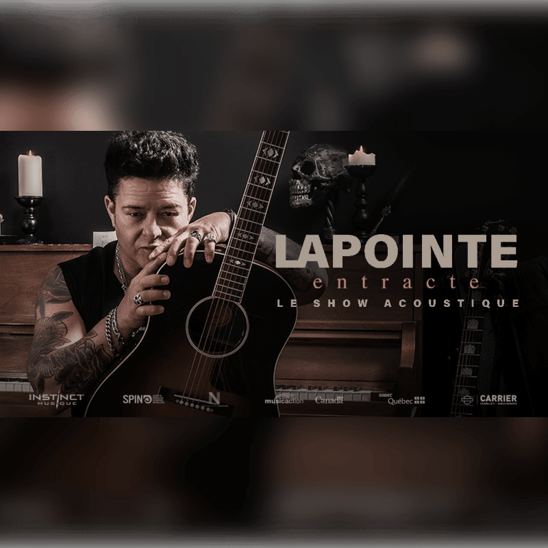 A tattooed man with an acoustic guitar rests his chin on his hand in the foreground, while the background features a piano, candles, and a skull.