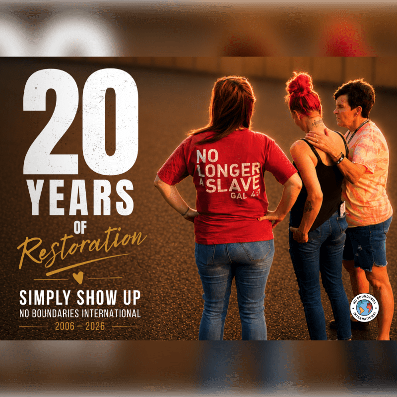 Three women stand together in the foreground with a large "20 YEARS OF Restoration" graphic on the left, against a blurred outdoor background.