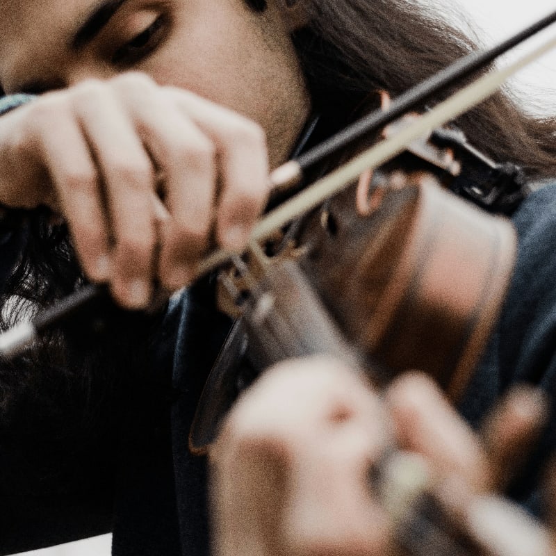 a woman is playing a violin outside