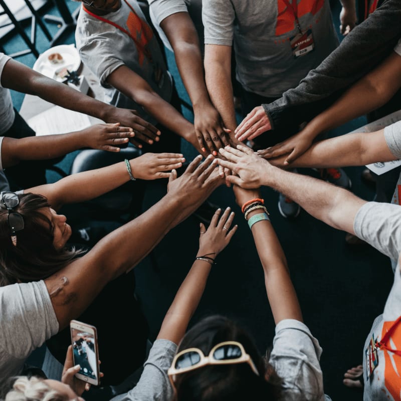 people with hands gathered in the middle