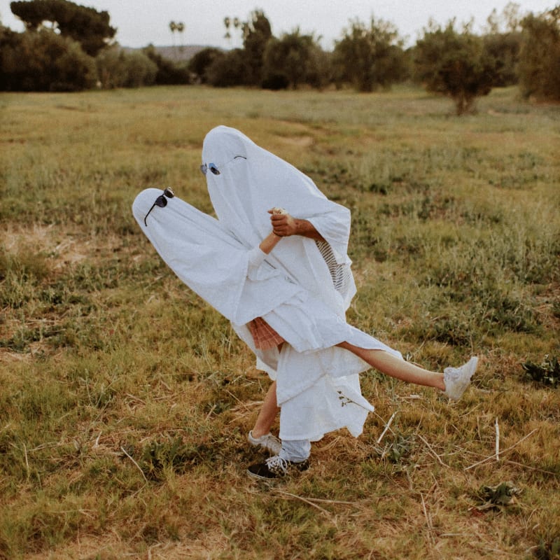 woman in white dress on brown grass field during daytime
