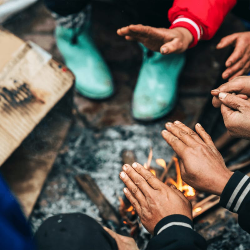 A group of people sitting around a fire