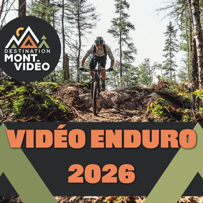 A mountain biker rides down a dirt trail in the foreground, with a forest and logo in the background.