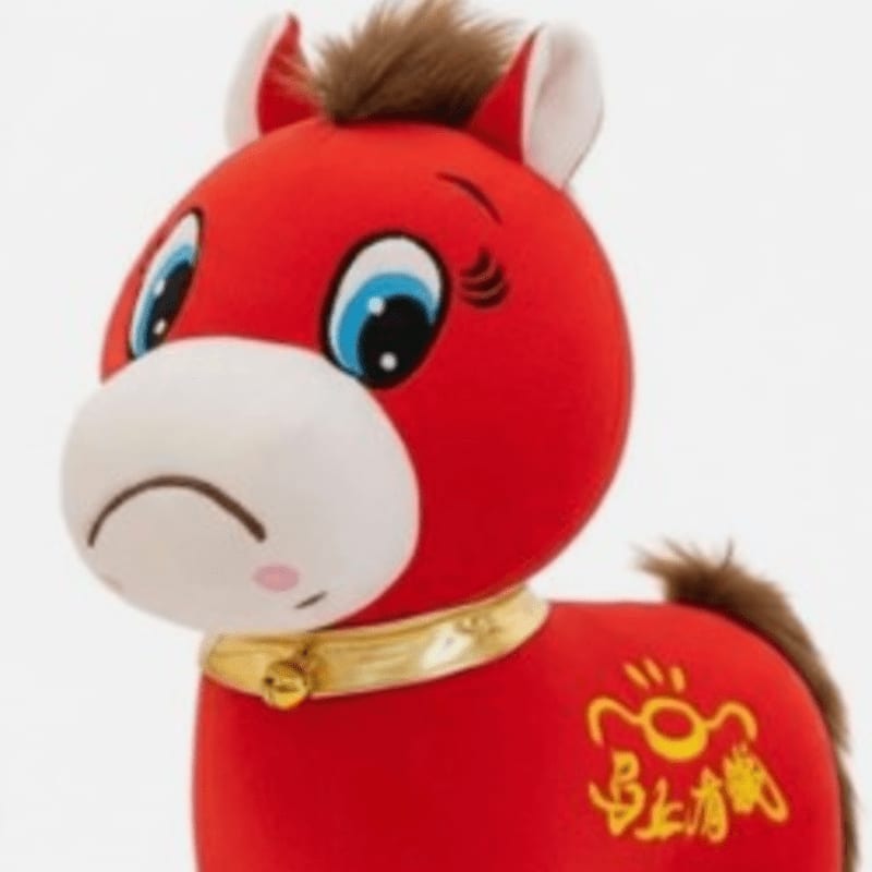A red plush horse with a golden collar and Chinese characters on its side stands against a plain white background.