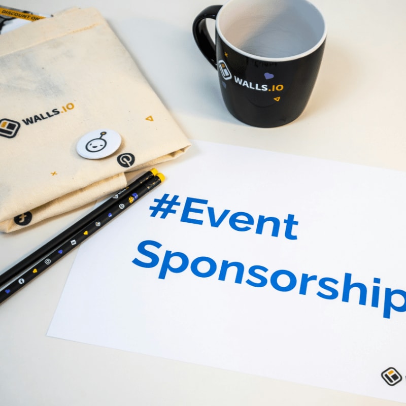 a cup of coffee next to a sign that says event sponsor