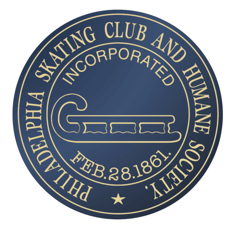 A dark blue circular emblem with a cream-colored outline features a stylized sled in the foreground and text around the perimeter in the background.