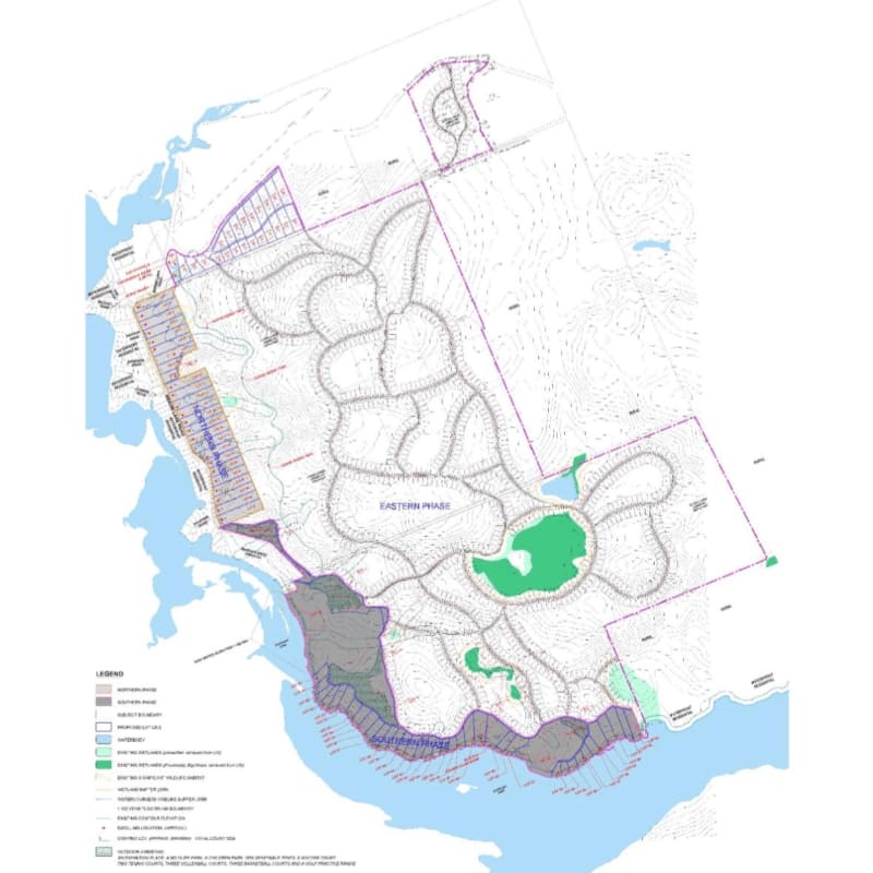A detailed site plan with a body of water and shoreline in the foreground, and a network of roads and green spaces within a development labeled "EASTERN WOODS" in the background.