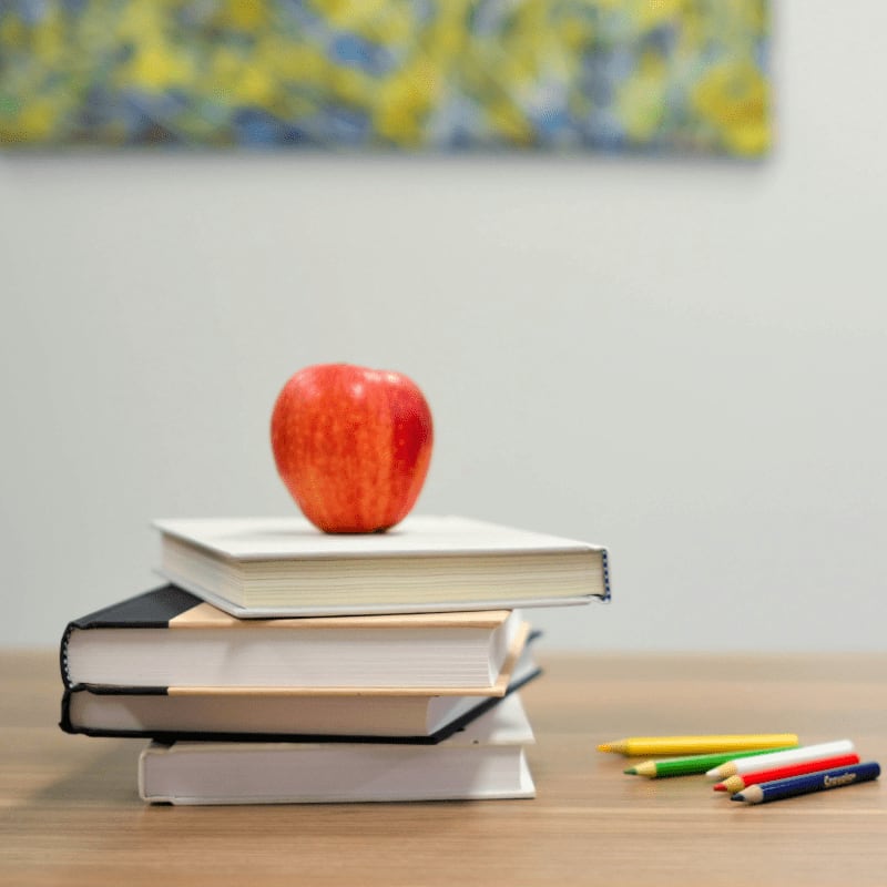 red apple fruit on four pyle books