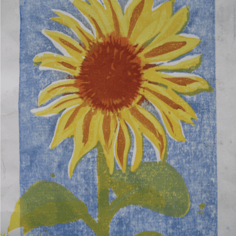 A vibrant yellow sunflower with a reddish-brown center and green leaves stands against a textured blue background.