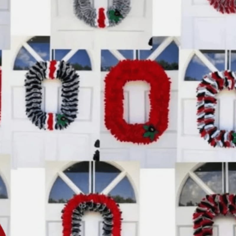 Several "O" shaped wreaths in red, black, and white are displayed on white doors with arched windows in the background.