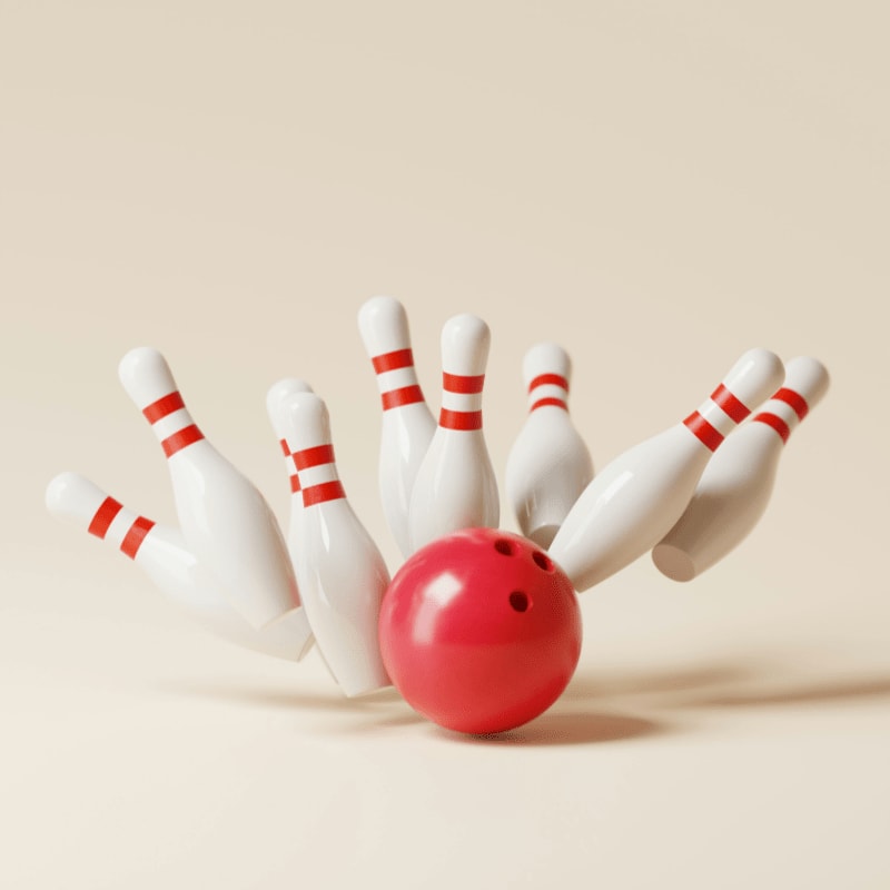 a red bowling ball crashing into the pins