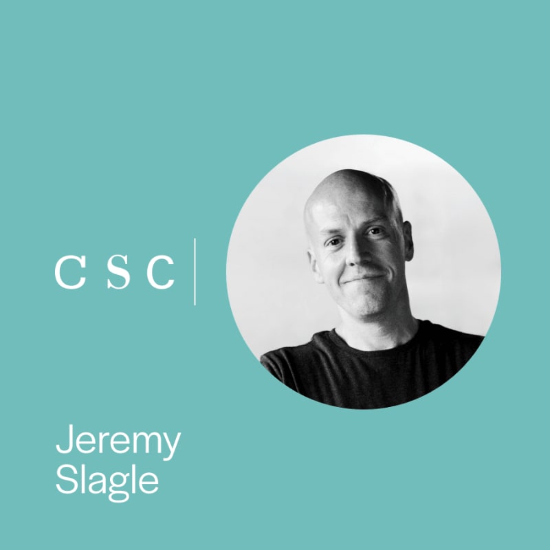 A black and white portrait of a smiling, bald man is presented in a circle on the right, with the letters "csc" and the name "Jeremy Slagle" on the left, all against a teal background.