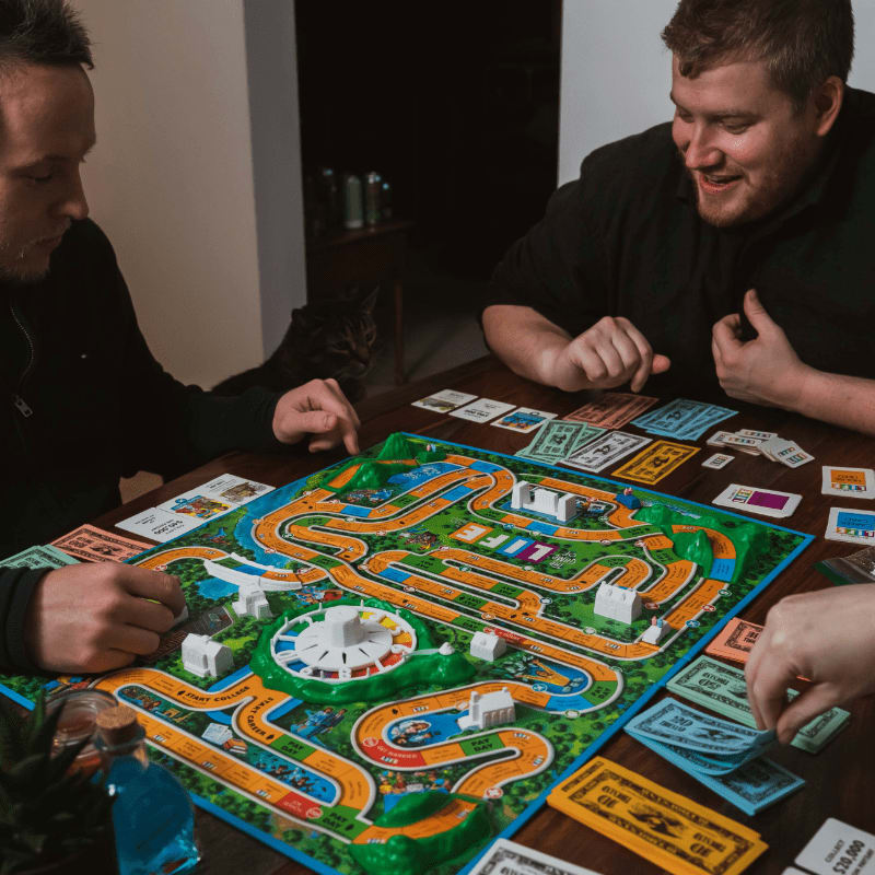 two men playing a game of monopoly on a table