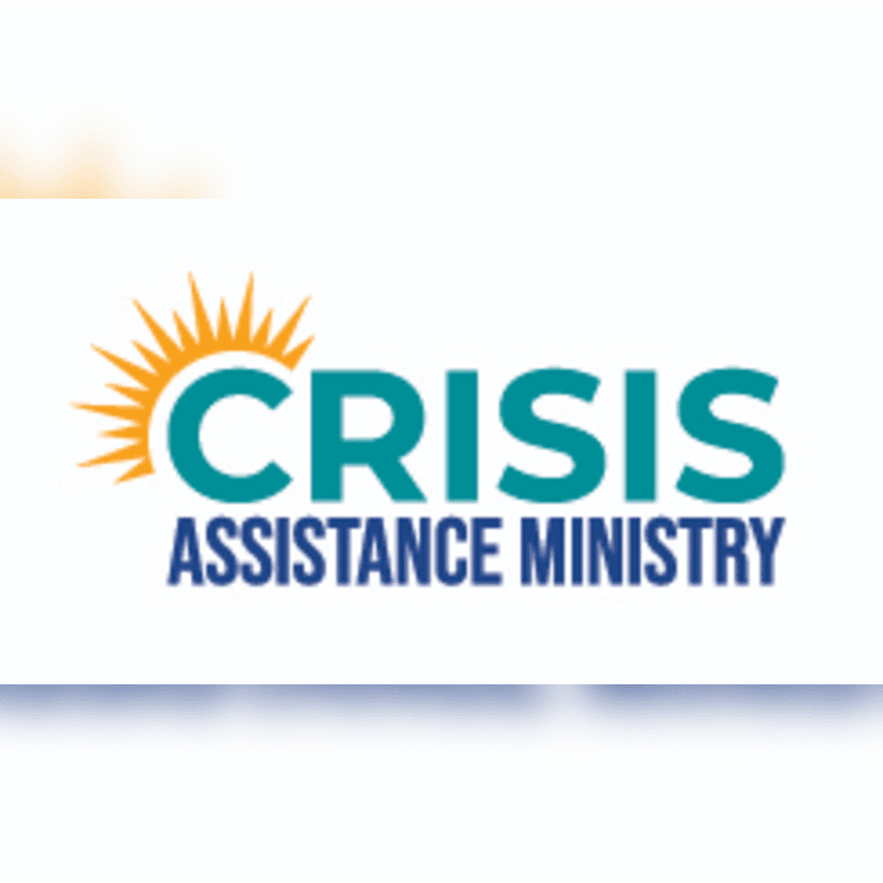 A teal logo with an orange sunburst on the left reads "CRISIS ASSISTANCE MINISTRY" in teal and blue text against a white background with a subtle blue shadow at the bottom.