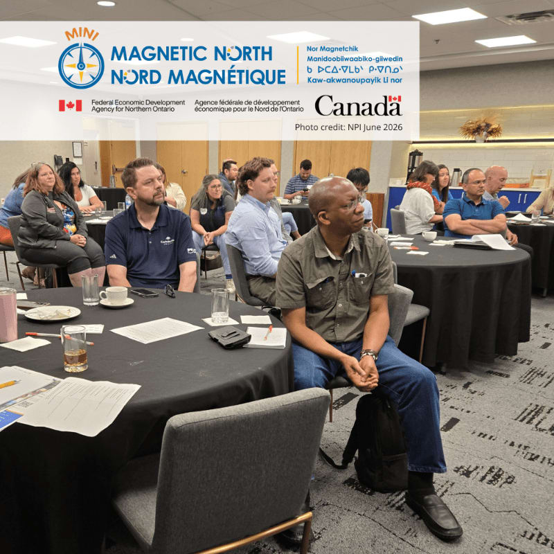 In the foreground, men and women sit at round tables in a conference room, while the background features a banner with "MAGNETIC NORTH" and Canadian government logos.
