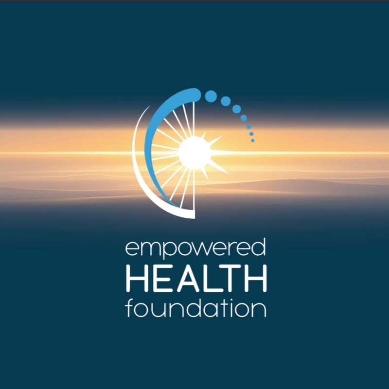 A stylized sunburst logo for "empowered HEALTH foundation" is centered against a gradient background of deep blue fading to a bright, hazy orange horizon.