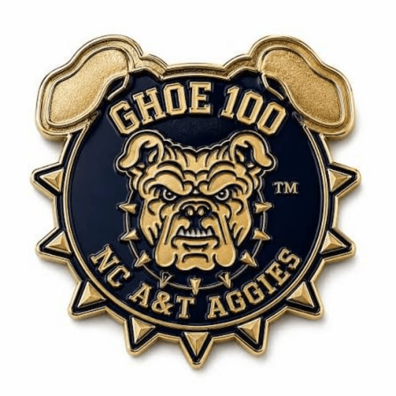 A gold and navy blue enamel pin featuring a bulldog's head and the text "GHOE 100 NC A&T AGGIES" is set against a plain white background.