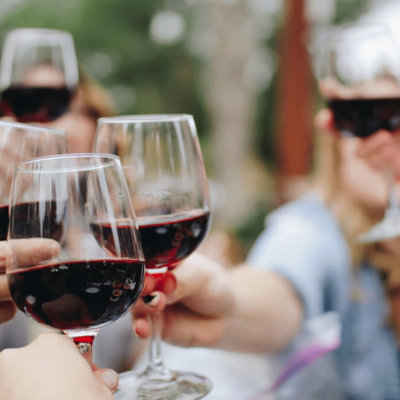 people tossing their clear wine glasses