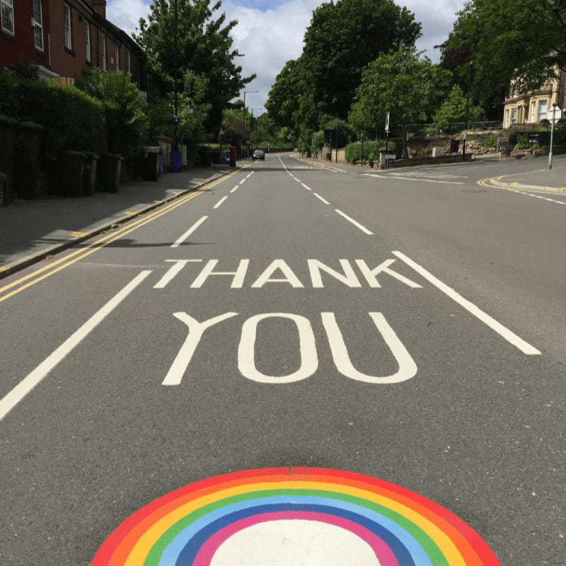 black asphalt road with rainbow sign